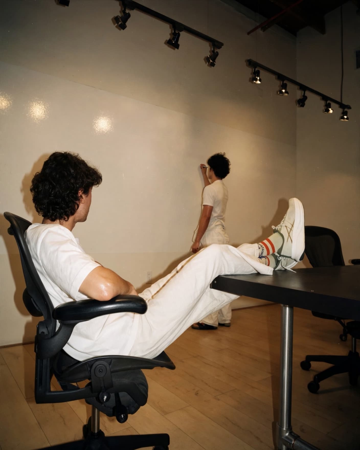 Two of the team in the Venice warehouse, feet up on the table